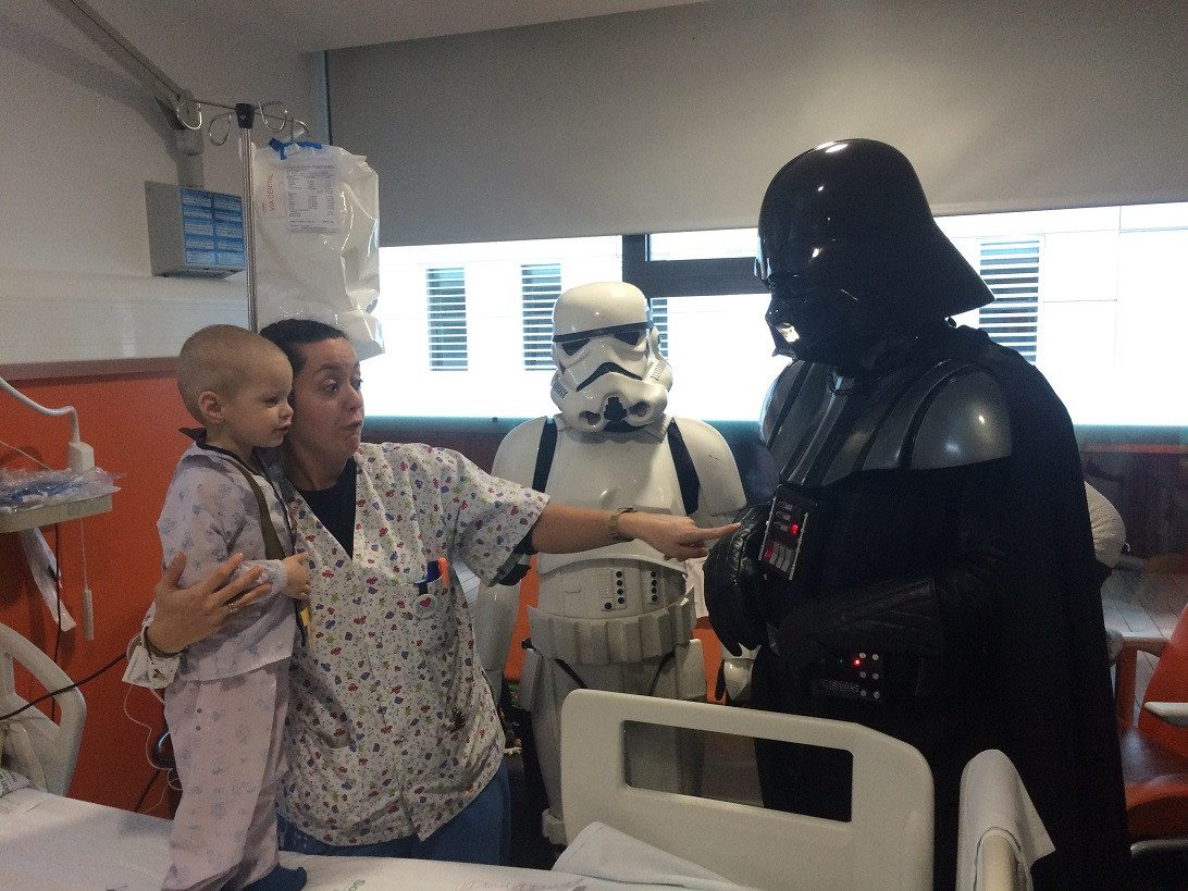 Esta imagen ilustra que: Los niños y niñas ingresados reciben la visita de los personajes de Star Wars